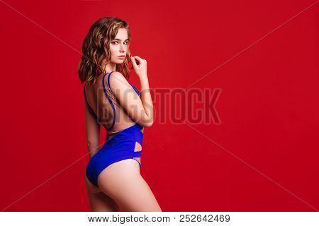 Pretty Bikini Model In Studio On Red Background
