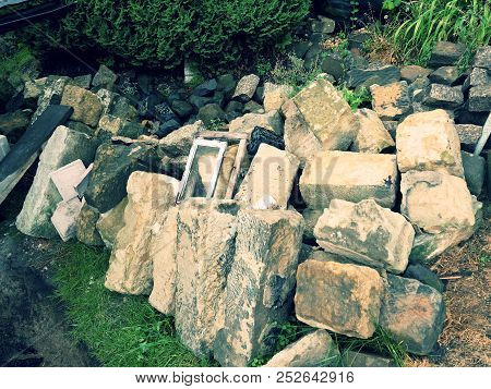Autentic And Decorative Building Stones In Pile. Old Heavy Sandstone Blocks Rest After Rebuilding.