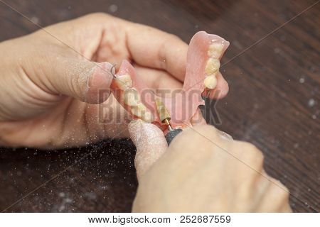 Dental technician make denture prothesis in dental laboratory, hands, close up