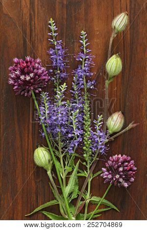 A Beautiful Summer Bouquet, Wildflowers, Wild Onions, Veronica Long-leaved Violet On A Wooden Backgr