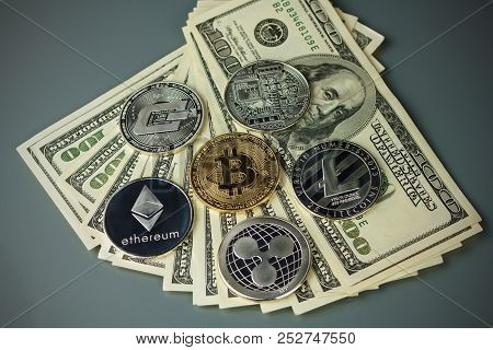Coins Of Different Crypto-currencies With Dollars. Bitcoin, Dash, Ripple, Ethereum Litecoin