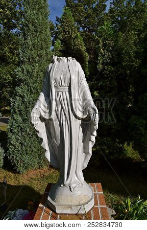 A Concrete Statue Of The Virgin Mary Is A Victim Of Vandalism With The Decapitation Of The Head.