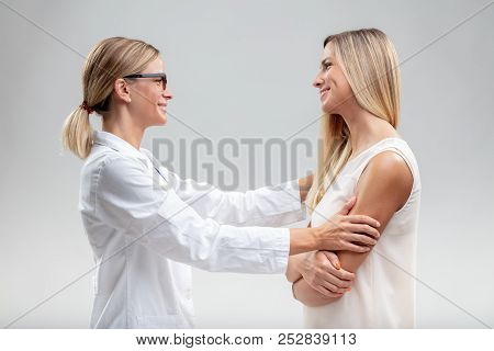 Female Doctor In A White Lab Coat Embracing A Woman Patient With A Quiet Smile Of Satisfaction And P