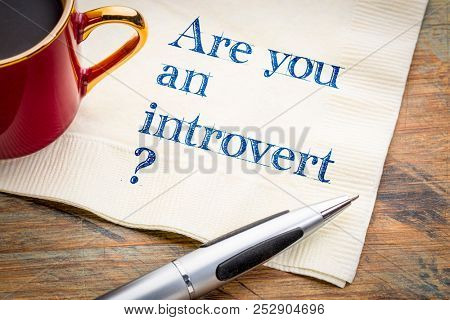 Are you an introvert? Handwriting on a napkin with a cup of coffee.