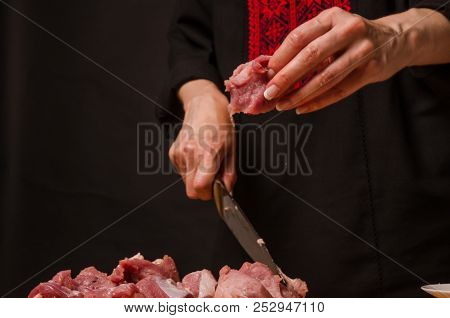 Female Hands With A Knife In Their Hand Cut Fresh Meat On A Table