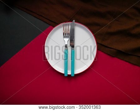 Cutlery Set With Plate. Dish, Fork And Knife, Copy Space, Colored Background, Closeup, Top View