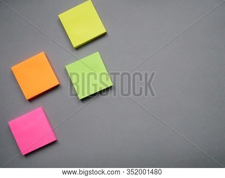Collection Of Different Colored Sheets Of Note Papers Ready For Your Message. Isolated On Gray Backg