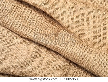 Close Up View On Brown Burlap Textile. Texture Of Brown Baline. Crumpled Burlap Fabric, An Abstract 
