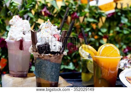 Panning Shot Going From Ice Cream And Chocolate Laden Shakes To Healthy Orange Juice With Slices In 