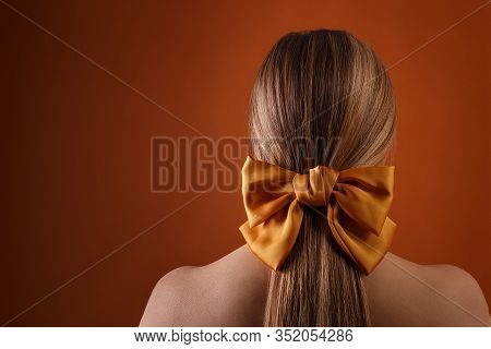 Blond Female Hairstyle With Color Ribbon On Orange Wall Background With Copyspace. Close Up Of Blond