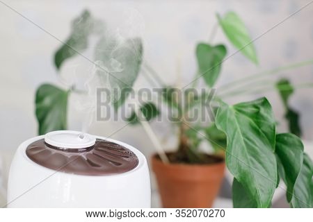 Close Up Photo Of White Air Humidifier Spreading Steam. Humidification Of Dry Air. Selective Focus O