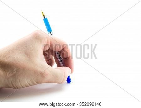 Male Left Hand With A Blue Ballpoint Pen Over A White Sheet Of Paper. Handle Upside Down, Upside Dow