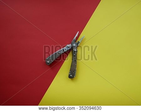 Multi Tool With Steel Handles On A White Colored Paper Background. Top View