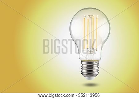 Filament Led Light Bulb Bulb With E27 Cap On A Yellow Background.