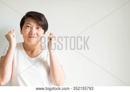 A Portrait Of A Happy Asian Woman In Funny Gesture; Smiling And Raising Her Hands And Arms Up In Pos