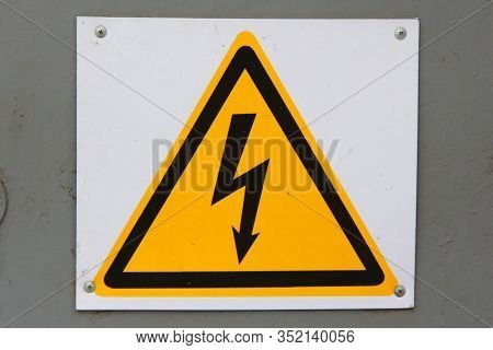 Sign Of Danger Of Electric Shock On White Isolation Background. Black Lightning Against A Yellow Tri