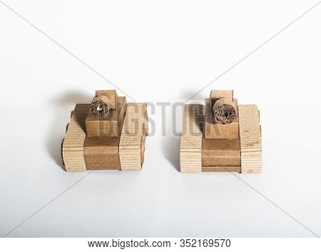 Two Toy Tanks Made By Children From Corrugated Cardboard Are Fighting. Toy Cardboard Tanks Isolated 