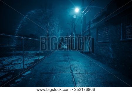 Dark and eerie urban city alley at nightÂ in the winter
