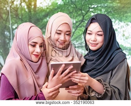 Three Beautiful Muslim Womae Wearing Hajab,using Mobile Phone For Taking Photo Together,model Posing