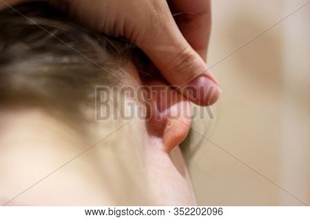 The Back Detail Of The Head With The Hair And Female Human Ear Doctor Exam Close Up. Selective Focus