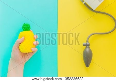 Flat Lay Stress, Antistress: Toy Squish Yellow Pineapple In Hand, Blood Pressure Monitor.bright Blue
