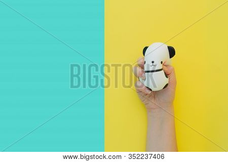 Flat Lay Antistress Toy Squish Black White Big Panda Squeezed In Hand.bright Yellow Blue Background.