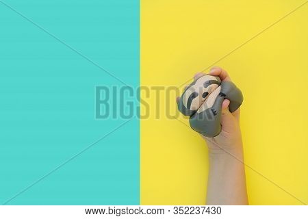 Flat Lay Antistress Toy Squish Gray Sloth Squeezed In Hand.bright Yellow Blue Background.compressing