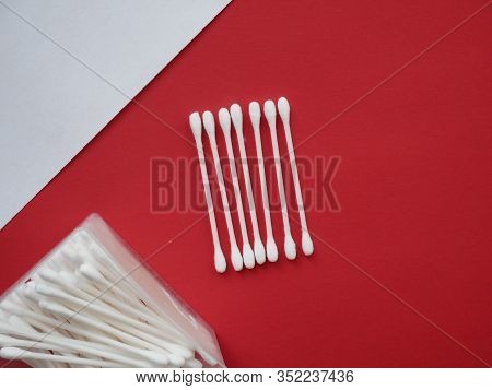 Flat Lay Composition With Cotton Swabs On Red Background. Top View Ear Sticks.