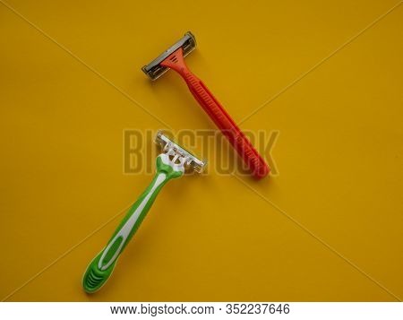 Two Unisex Razors On The Yellow Background. Top View. Copy Space