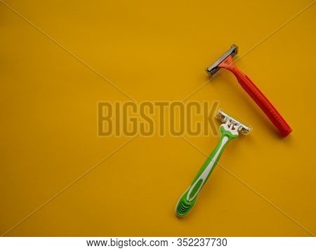 Two Unisex Razors On The Yellow Background. Top View. Copy Space