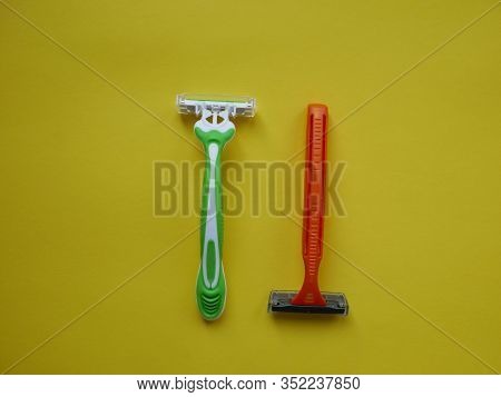 Two Unisex Razors On The Yellow Background. Top View. Copy Space