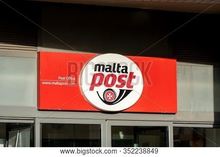 Bugibba, Malta - October 27, 2019: The Red Logo Of The Malta Post Office Above Entrance Of Branch Of