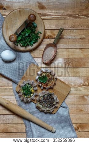 Open Buckwheat Pies With Various Vegetarian Fillings On A Wooden Background With A Rolling Pin And S