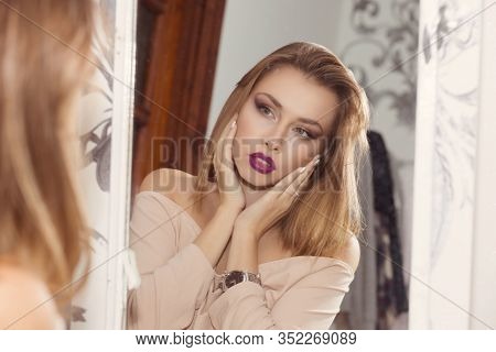 Beautiful Woman Girl At Home Looking At Her Self In The Mirror, Evaluating Herself. Full Makeup Brow