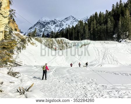 Yoho National Park, Canada - March 22nd, 2020: A Group Of Hikers Walking Towards The Frozen Wapta Fa