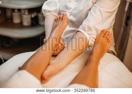 Caucasian Girl Lying While A Doctor Is Messaging Her Legs In A Spa Salon