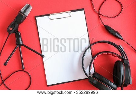Headphones, Microphone And Clipboard With White Paper On Red Background. Concept Music Or Podcast. T