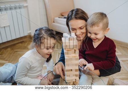 Caucasian Mother Is Teaching Her Kids How Play Jenga While They Are Listening Attentive