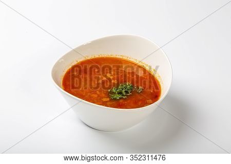 Beef Goulash Soup With Tongue. A White Oval Plate With Red Soup Stands On A White Background