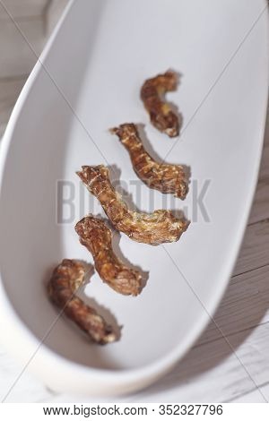 Dried Homemade Chicken Necks In White Bowl. Dog And Cat Chewy Jerky And Treats Made With Dehydratati