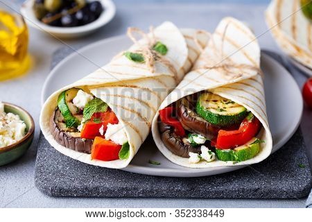 Wrap Sandwich With Grilled Vegetables And Feta Cheese On A Plate. Grey Background. Close Up.