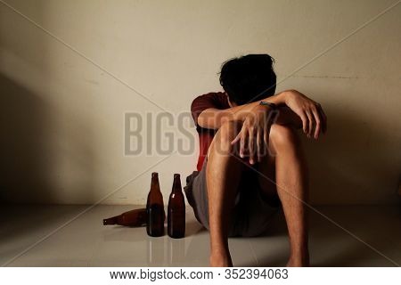 Drunken Man With Beer Bottle Are Having Stress In Life And Sitting Alone In A Empty Room, Sad ,lonel