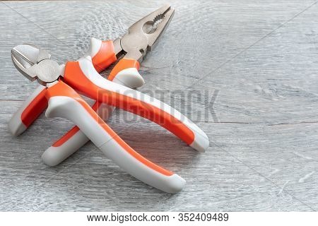A Set Of Two Different Types Of Pliers And Side Knives On A Gray Laminate. Image On The Theme Of Rep