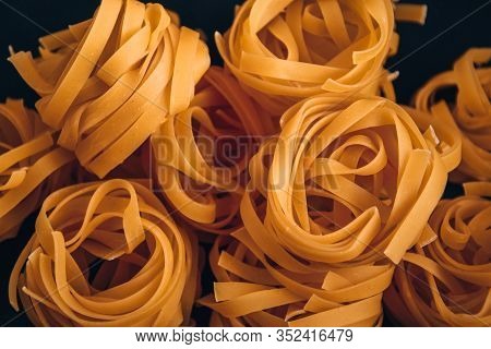 Pasta Alluovo, Tagliatelle Pasta, Round Balls Of Raw Pasta On Black Background, Close Up Of A Raw Dr