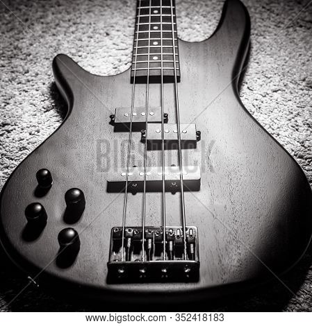 Left-handed Bass Electric Guitar With Four Strings In Black And White. Popular Rock Musical Instrume