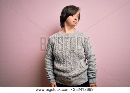 Young down syndrome woman wearing casual sweater over isolated background smiling looking to the side and staring away thinking.