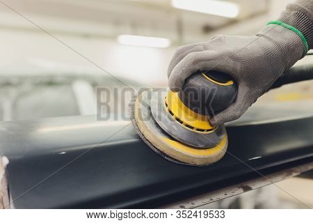 Auto Mechanic Preparing The Car For Paint Job By Applying Polish With The Power Buffer Machine