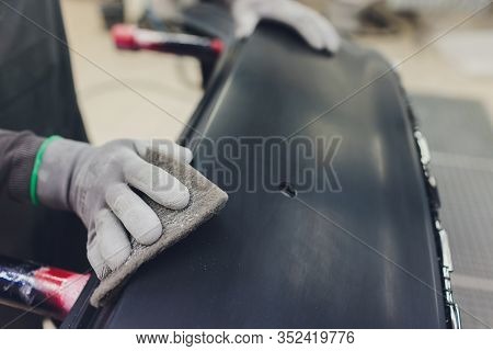 Auto Mechanic Preparing The Car For Paint Job By Applying Polish With The Power Buffer Machine