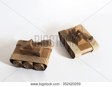 Two Toy Tanks Made By Children From Corrugated Cardboard Are Fighting. Toy Cardboard Tanks Isolated 