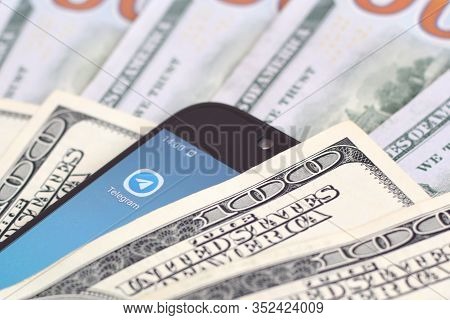 Smartphone Screen With Telegram App And Lot Of Hundred Dollar Bills. Business And Social Networking 